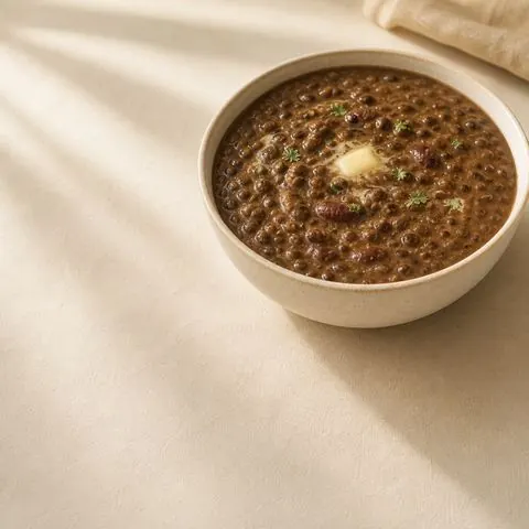 Dal makhani — slow-cooked black urad and rajma in a rich buttery gravy, photographed from above in a steel bowl